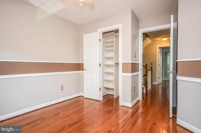 an empty room with wooden floor and closet area