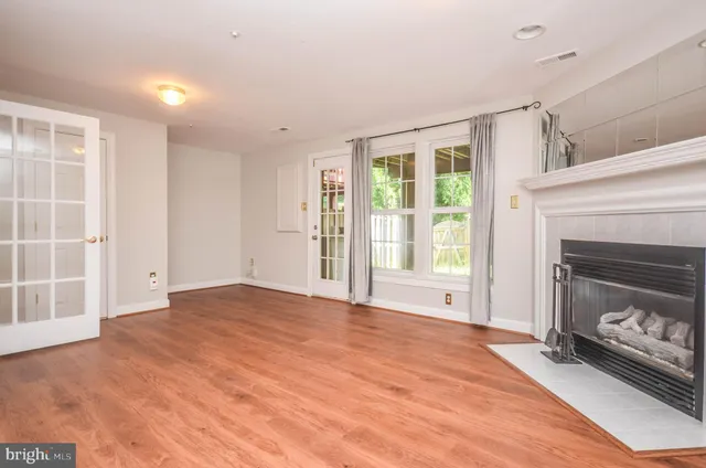 a view of an empty room with a fireplace and a window