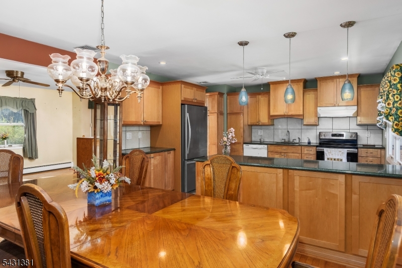 1089 Green Pond Road Newfoundland, NJ 07435 - Photo 9 of 34 a kitchen with stainless steel appliances granite countertop a sink dishwasher a dining table and chairs with wooden floor