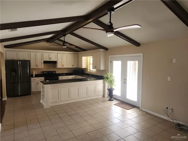 a large white kitchen with a stove and a refrigerator