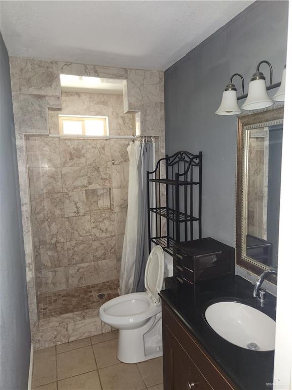 3021 Nyssa Avenue McAllen, TX 78501 - Photo 22 of 24 a bathroom with a granite countertop toilet sink and mirror
