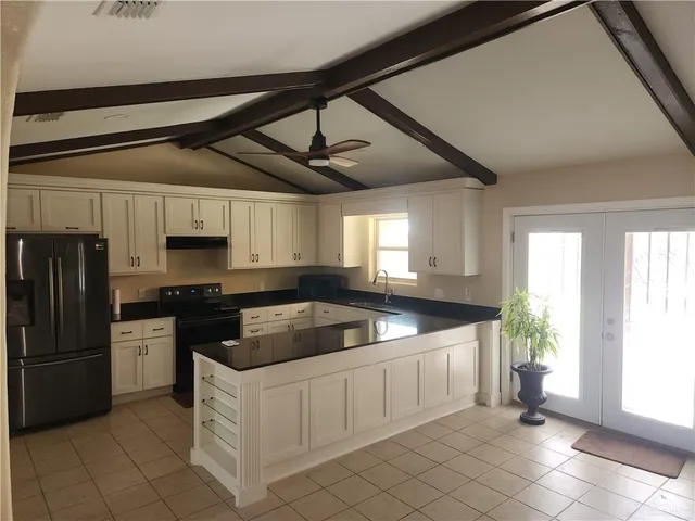 a kitchen with stainless steel appliances granite countertop a sink a stove and a refrigerator