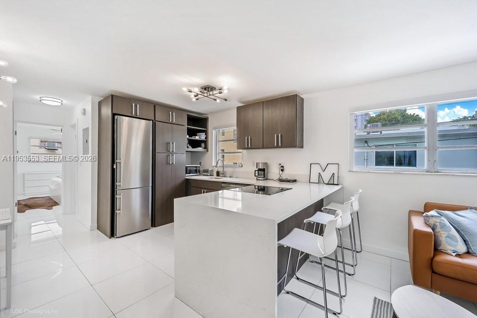 710 11th Street, Unit 8 Miami Beach, FL 33139 - Photo 6 of 15 a kitchen with stainless steel appliances a refrigerator and a microwave