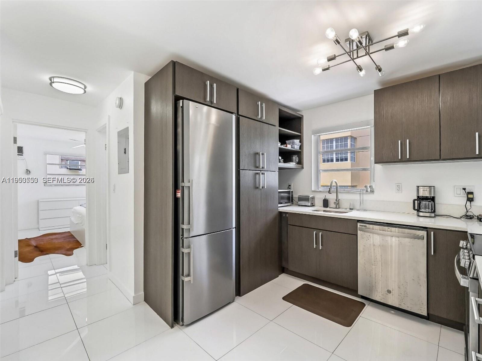 710 11th Street, Unit 8 Miami Beach, FL 33139 - Photo 7 of 15 a kitchen with stainless steel appliances granite countertop a refrigerator and a sink