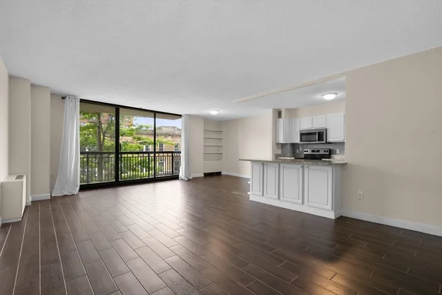 a view of kitchen with refrigerator and wooden floor
