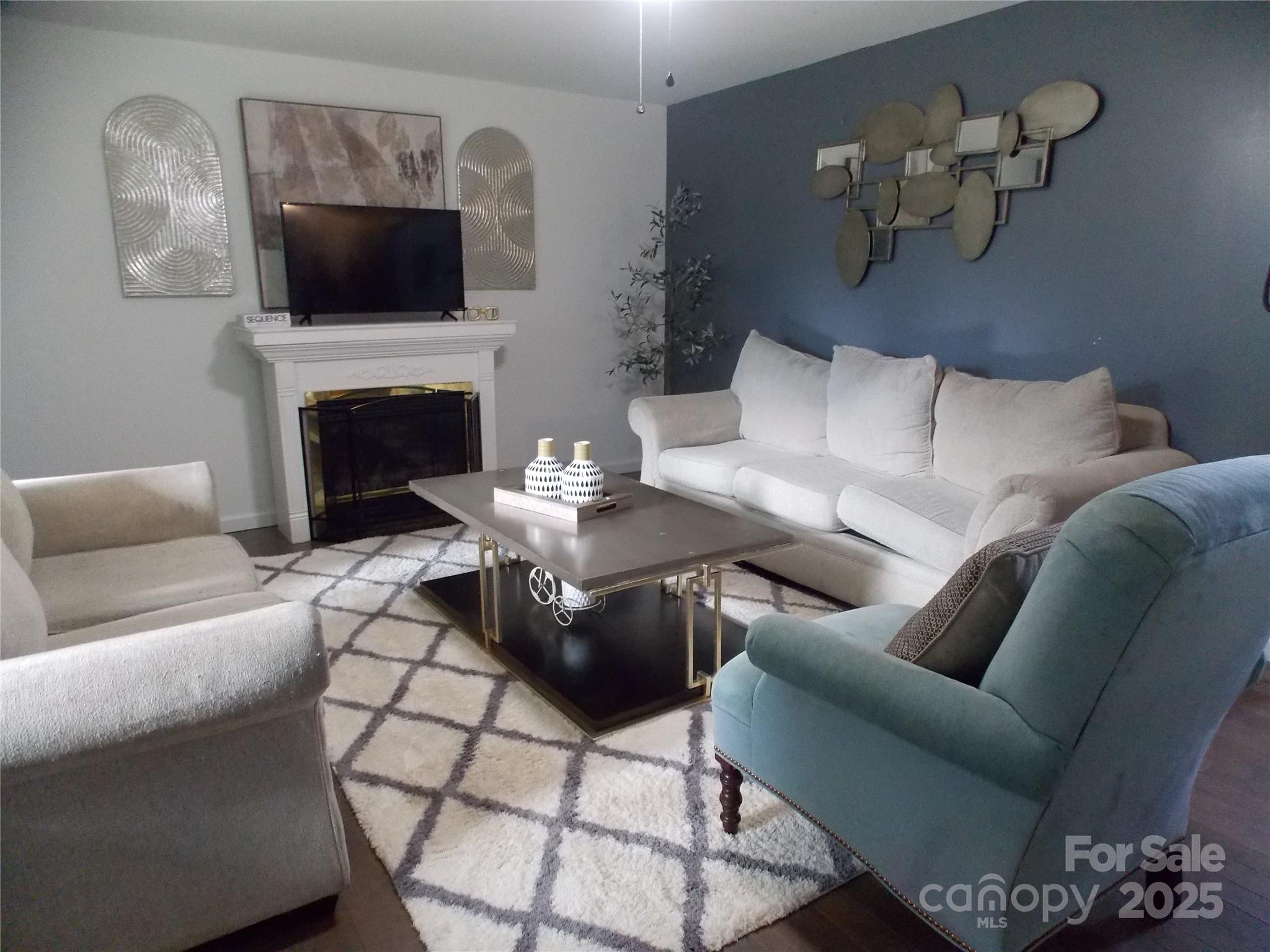 314 Cypress Street Hudson, NC 28638 - Photo 2 of 16 a living room with furniture a fireplace and a flat screen tv