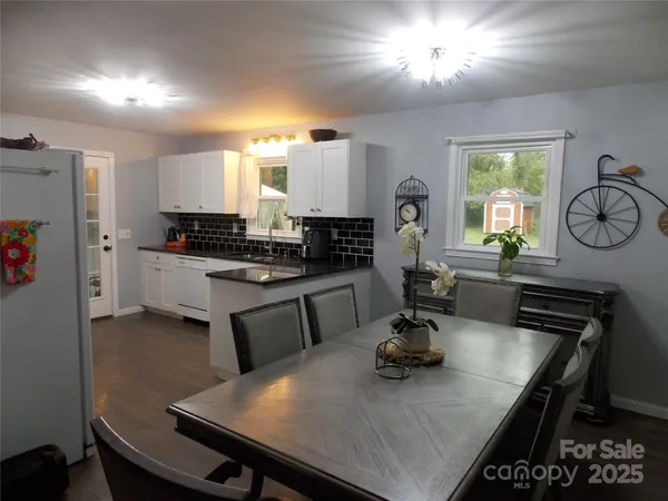 a kitchen with a table chairs a sink dishwasher stove and cabinets