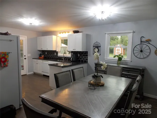 a kitchen with a table chairs a sink dishwasher stove and cabinets