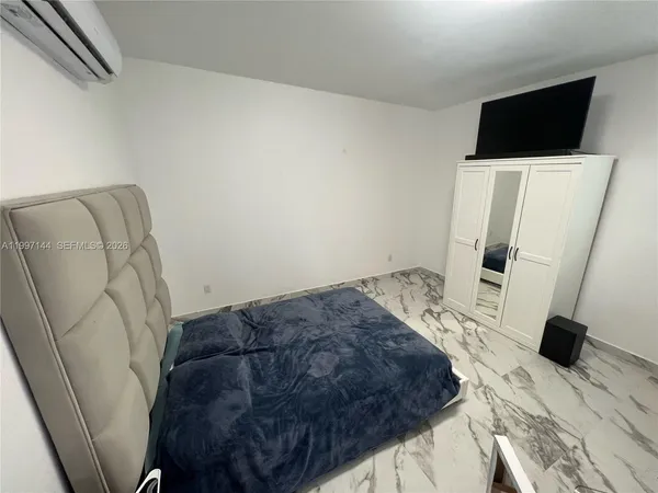 a bedroom with a bed and a flat screen tv