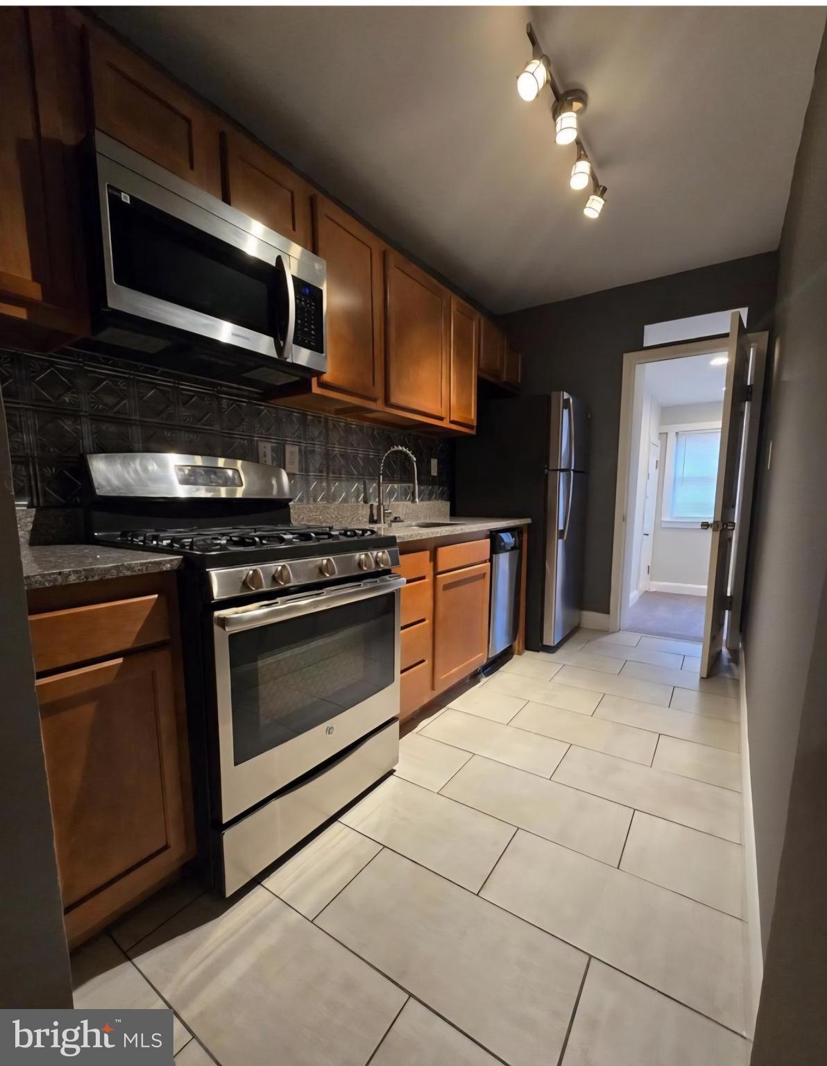 4044 7th Street Northeast, Unit 2 Washington, DC 20017 - Photo 2 of 6 a kitchen with granite countertop a stove and a microwave