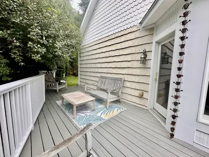 a view of a balcony with chairs and wooden floor