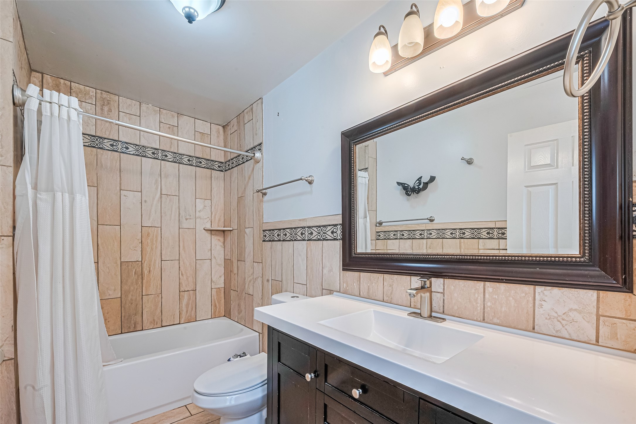 24314 Anderson Street Huffman, TX 77336 - Photo 36 of 48 a bathroom with a sink a toilet a mirror a vanity and bathtub