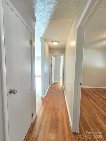 a view of a hallway with wooden floor
