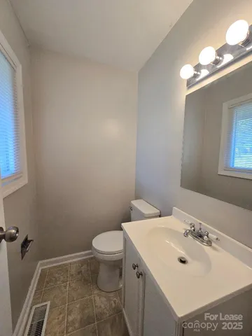 a bathroom with a sink mirror and toilet