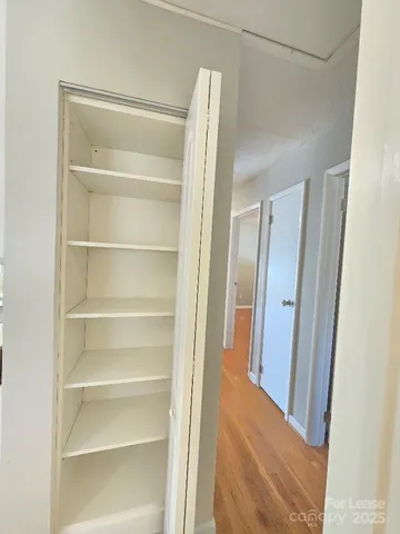 a view of walk in closet with empty racks