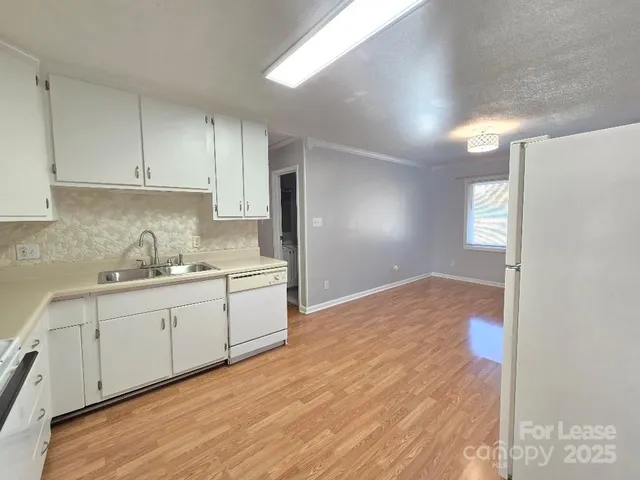 a kitchen with granite countertop white cabinets and white appliances