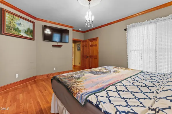 a bedroom with a bed and a painting on the wall