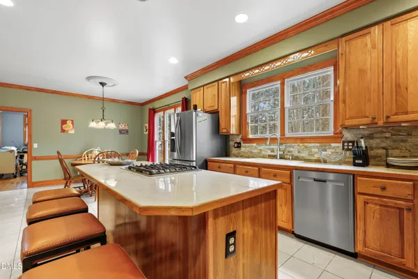 a kitchen with kitchen island granite countertop a sink and a stove