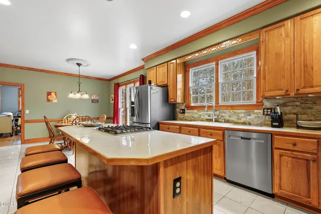 a kitchen with a stove a sink a dining table and chairs