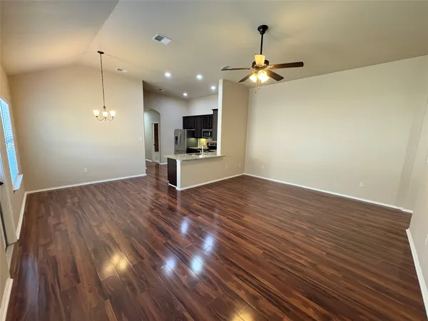 a view of a room with wooden floor a ceiling fan and window
