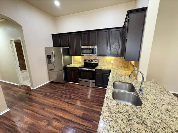 a kitchen with granite countertop wooden cabinets and stainless steel appliances