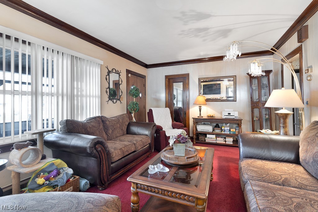8007 Snow Road Parma, OH 44129 - Photo 2 of 25 Carpeted living room with crown molding, a chandelier, and a healthy amount of sunlight