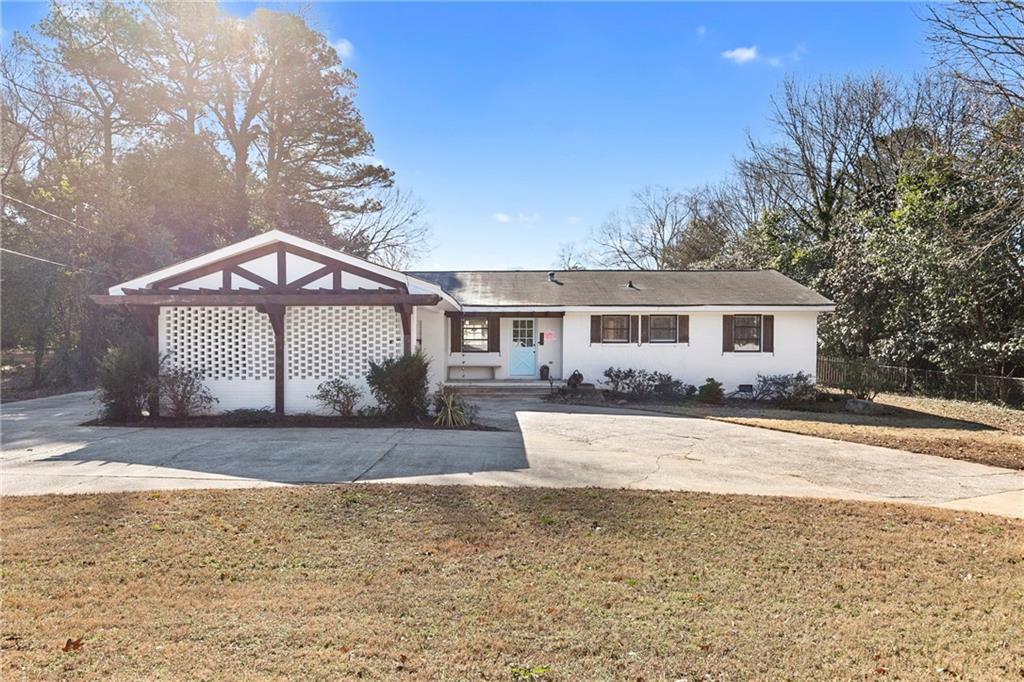 a view of a house with a yard and large tree