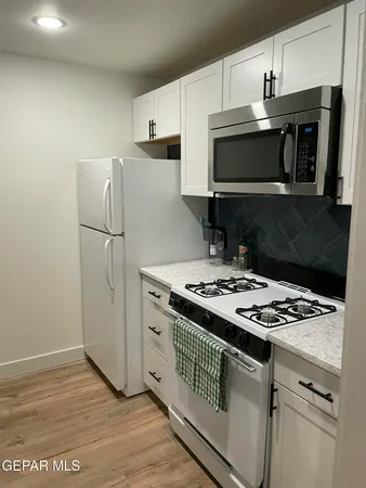 a kitchen with granite countertop a stove and a microwave