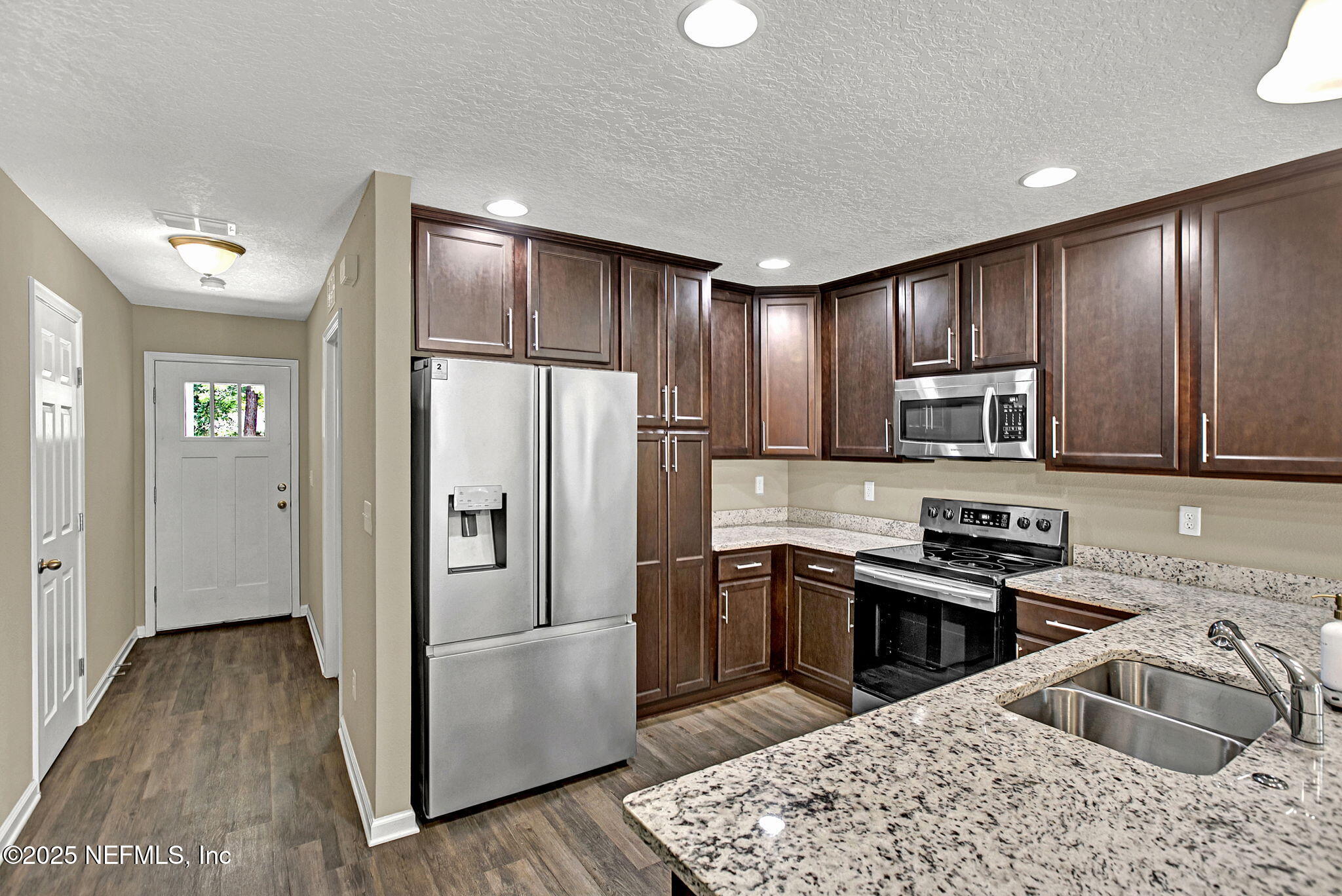 1206 Murray Drive Jacksonville, FL 32205 - Photo 11 of 23 a kitchen with kitchen island granite countertop wooden cabinets a refrigerator and a sink