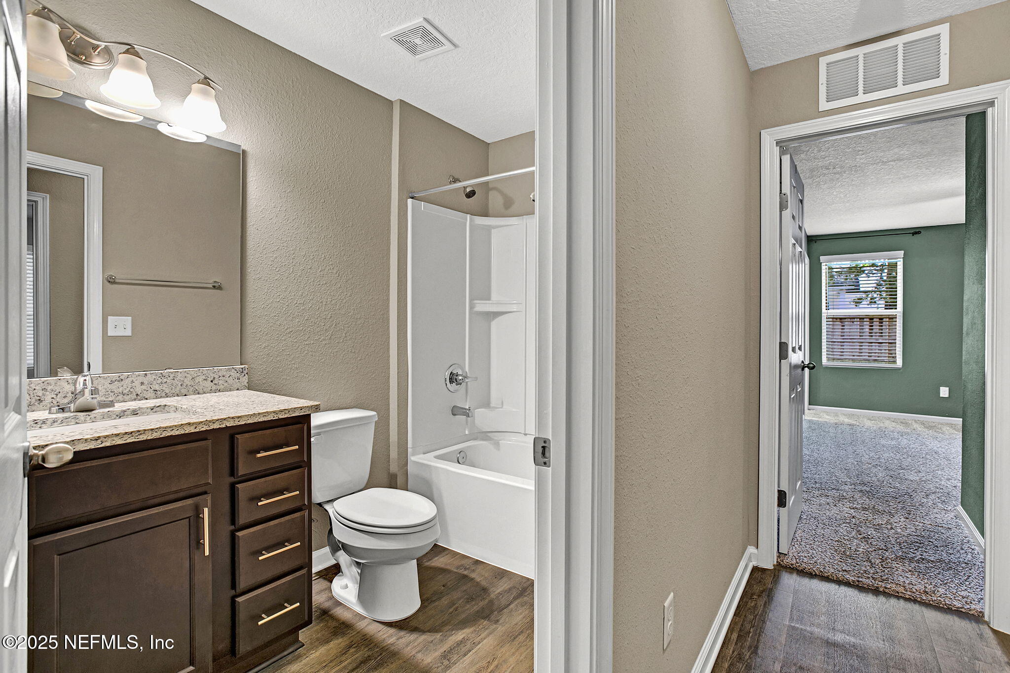 1206 Murray Drive Jacksonville, FL 32205 - Photo 18 of 23 a bathroom with a granite countertop toilet a sink and a mirror