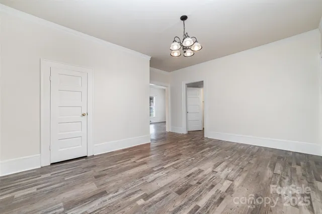 a view of an empty room with wooden floor and workspace