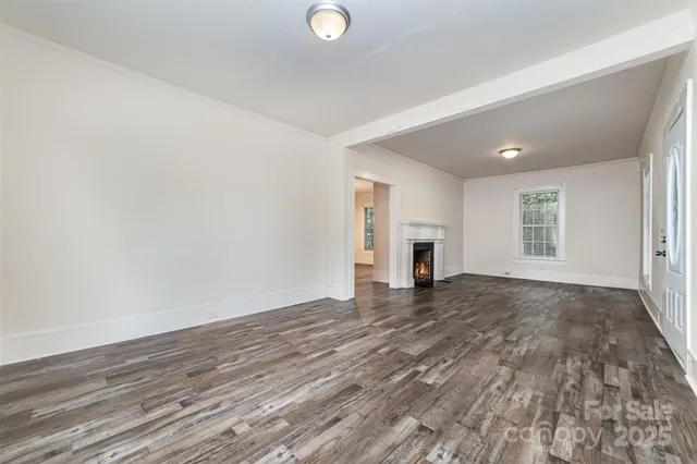 a view of empty room with wooden floor and fireplace