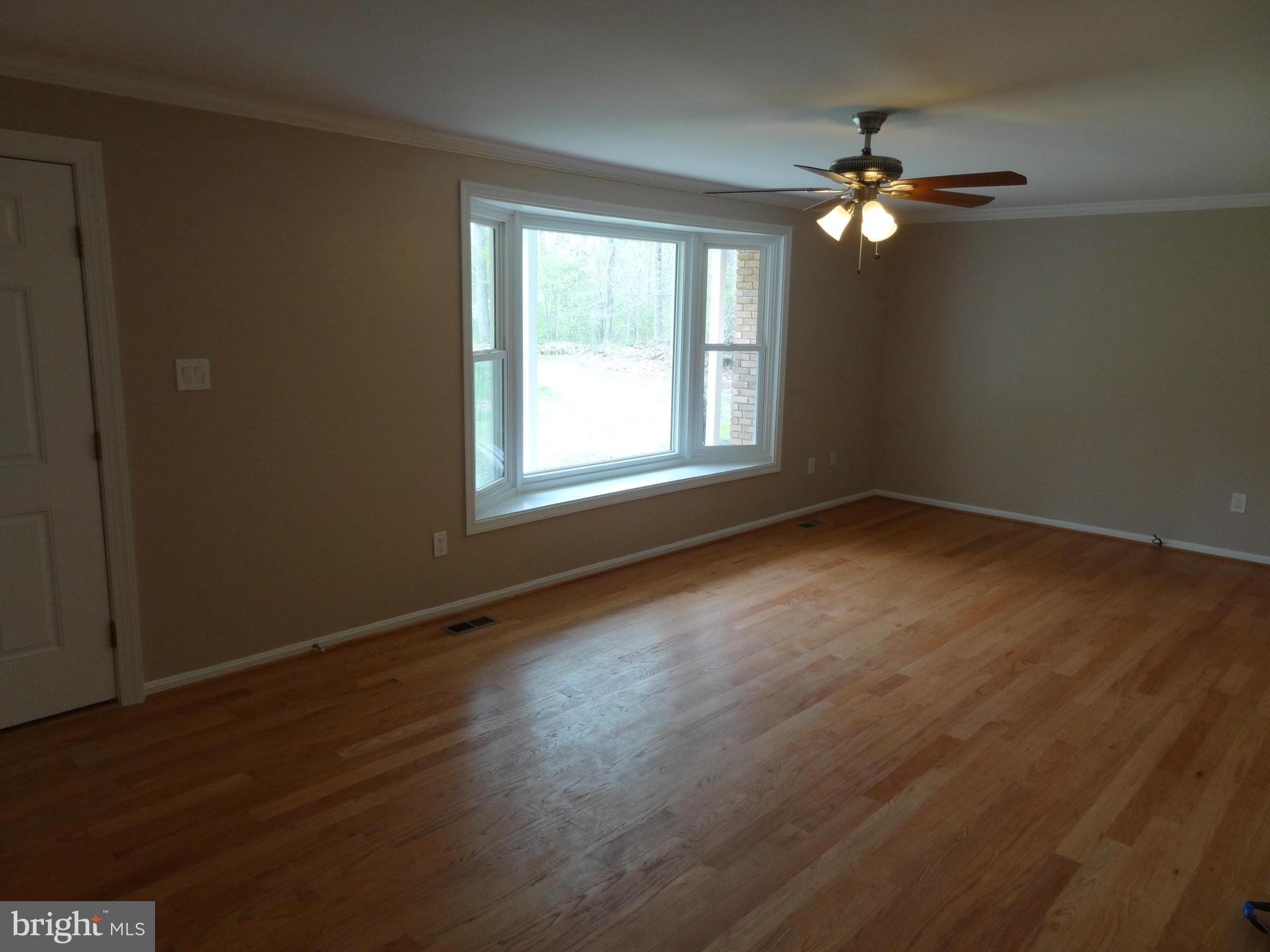 2835 Hambleton Road Riva, MD 21140 - Photo 4 of 30 a view of an empty room with wooden floor and a window