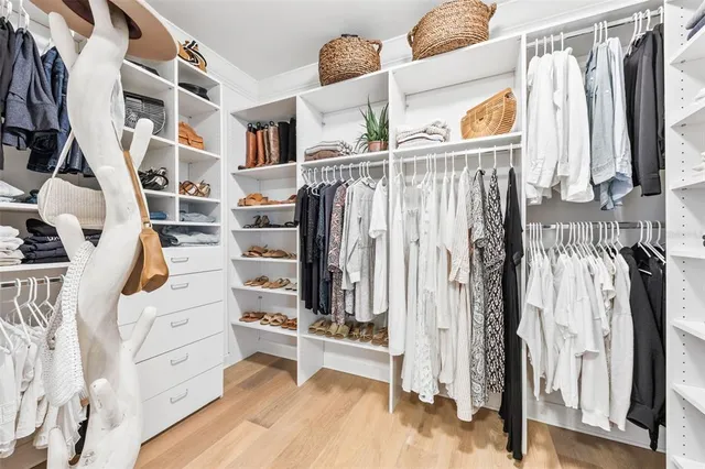 a view of walk in closet with clothes and shoes