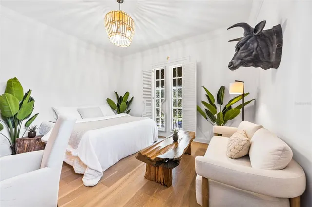 a bedroom with a bed a couch and potted plant