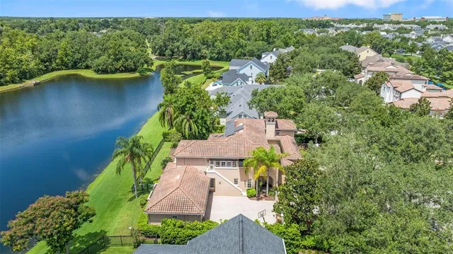 an aerial view of residential house with outdoor space and a lake view
