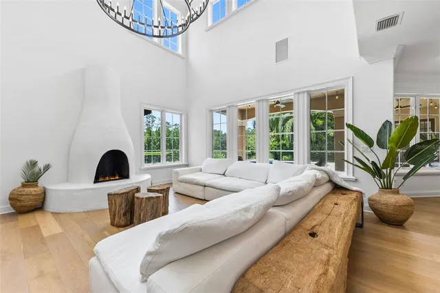 a living room with furniture a chandelier and a large window