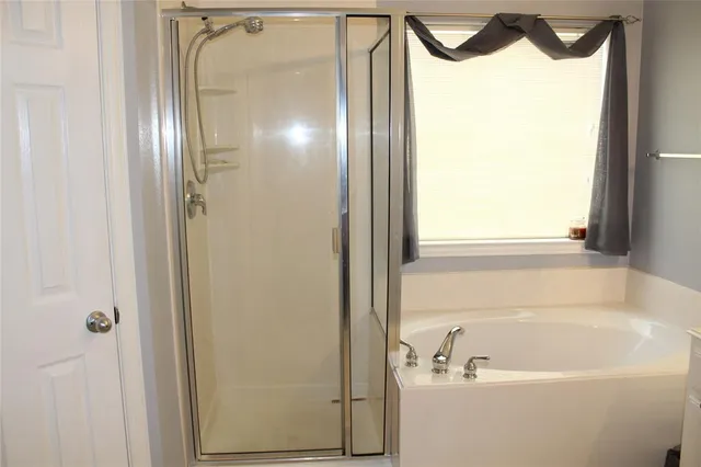 a bathroom with a bathtub and a shower