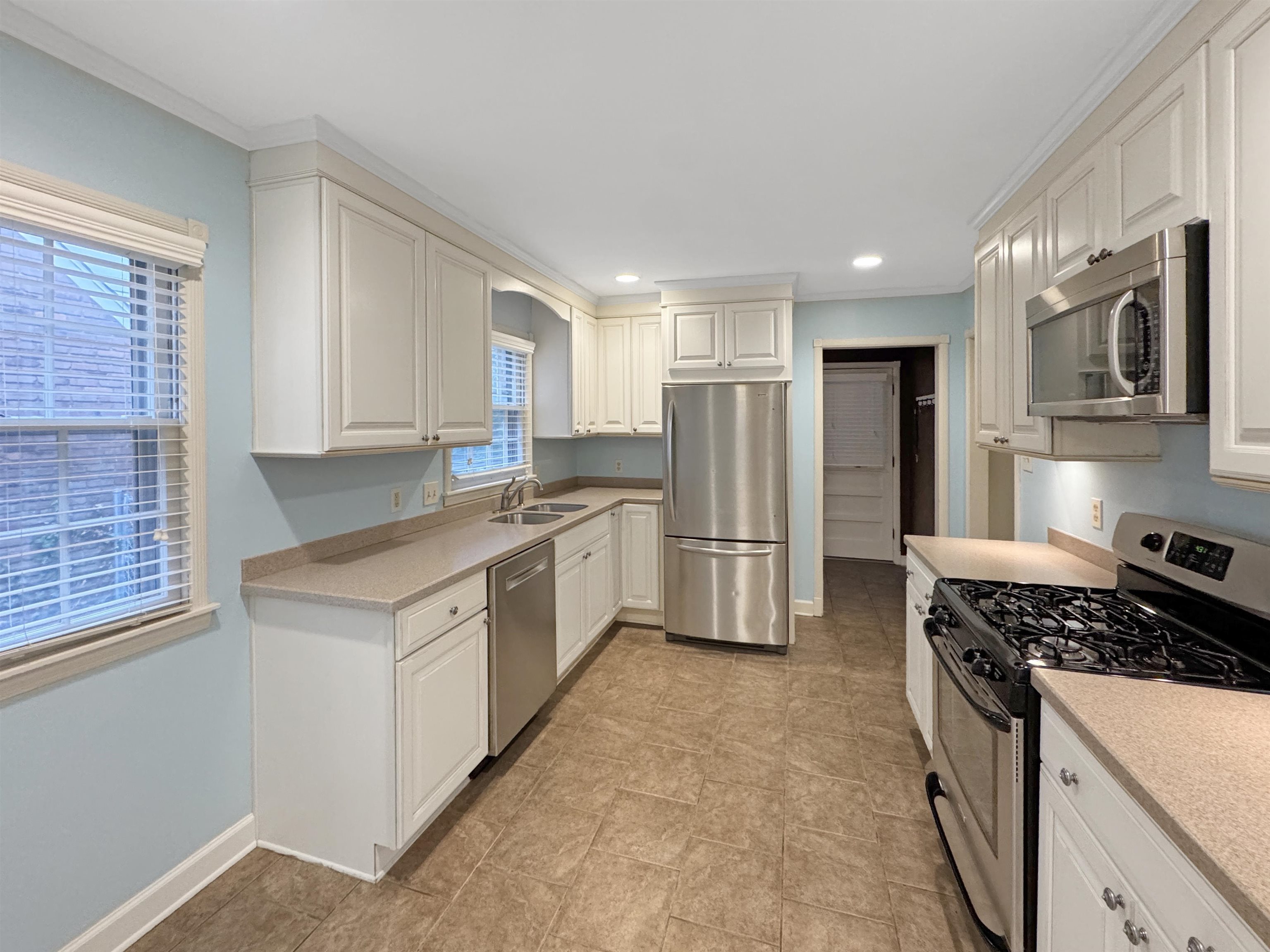 407 Meadvale Road Memphis, TN 38120 - Photo 11 of 37 a kitchen with refrigerator a stove a sink and cabinets