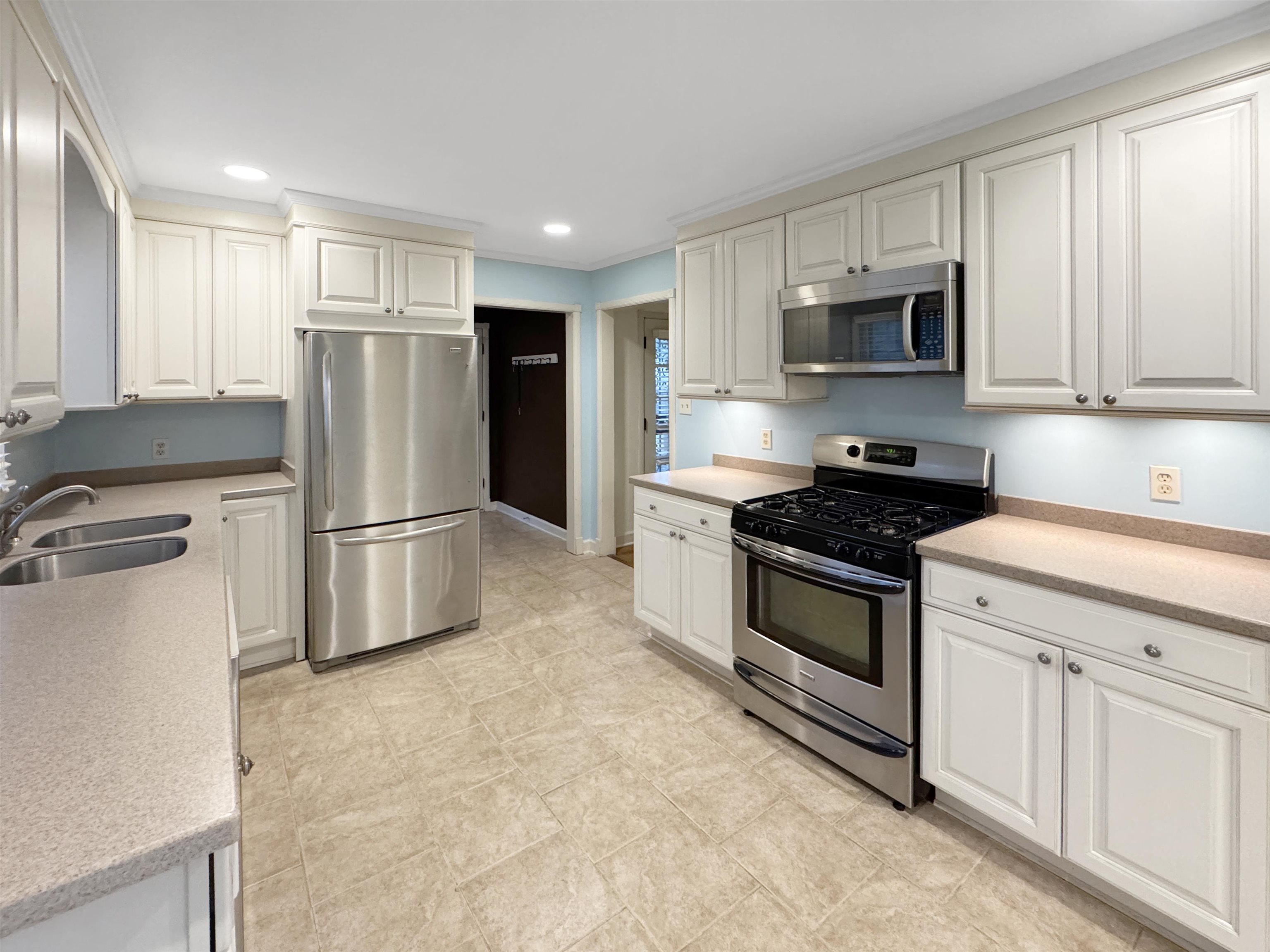 407 Meadvale Road Memphis, TN 38120 - Photo 12 of 37 a kitchen with stainless steel appliances granite countertop a refrigerator sink and white cabinets
