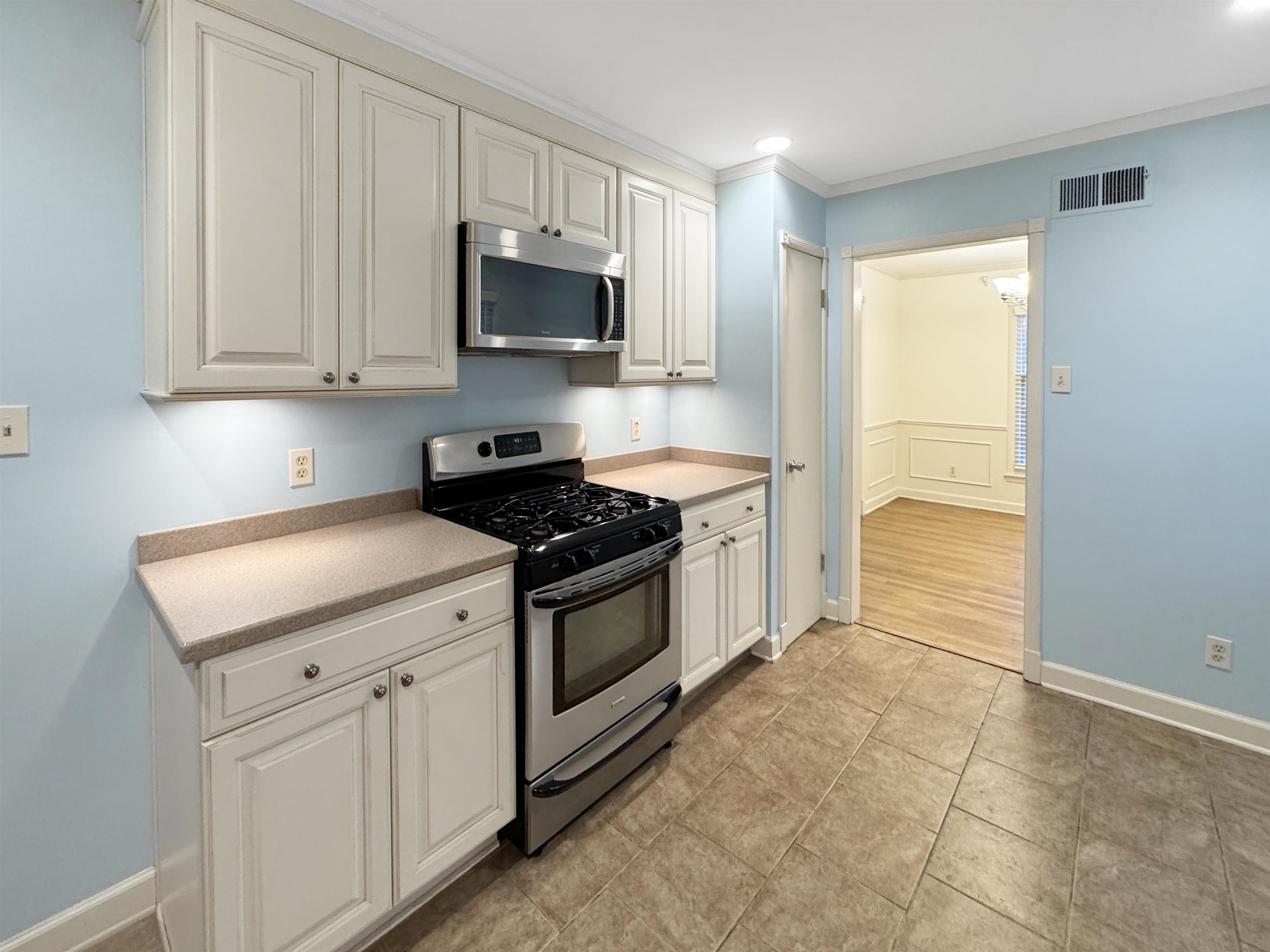 407 Meadvale Road Memphis, TN 38120 - Photo 12 of 36 a kitchen with white cabinets and appliances
