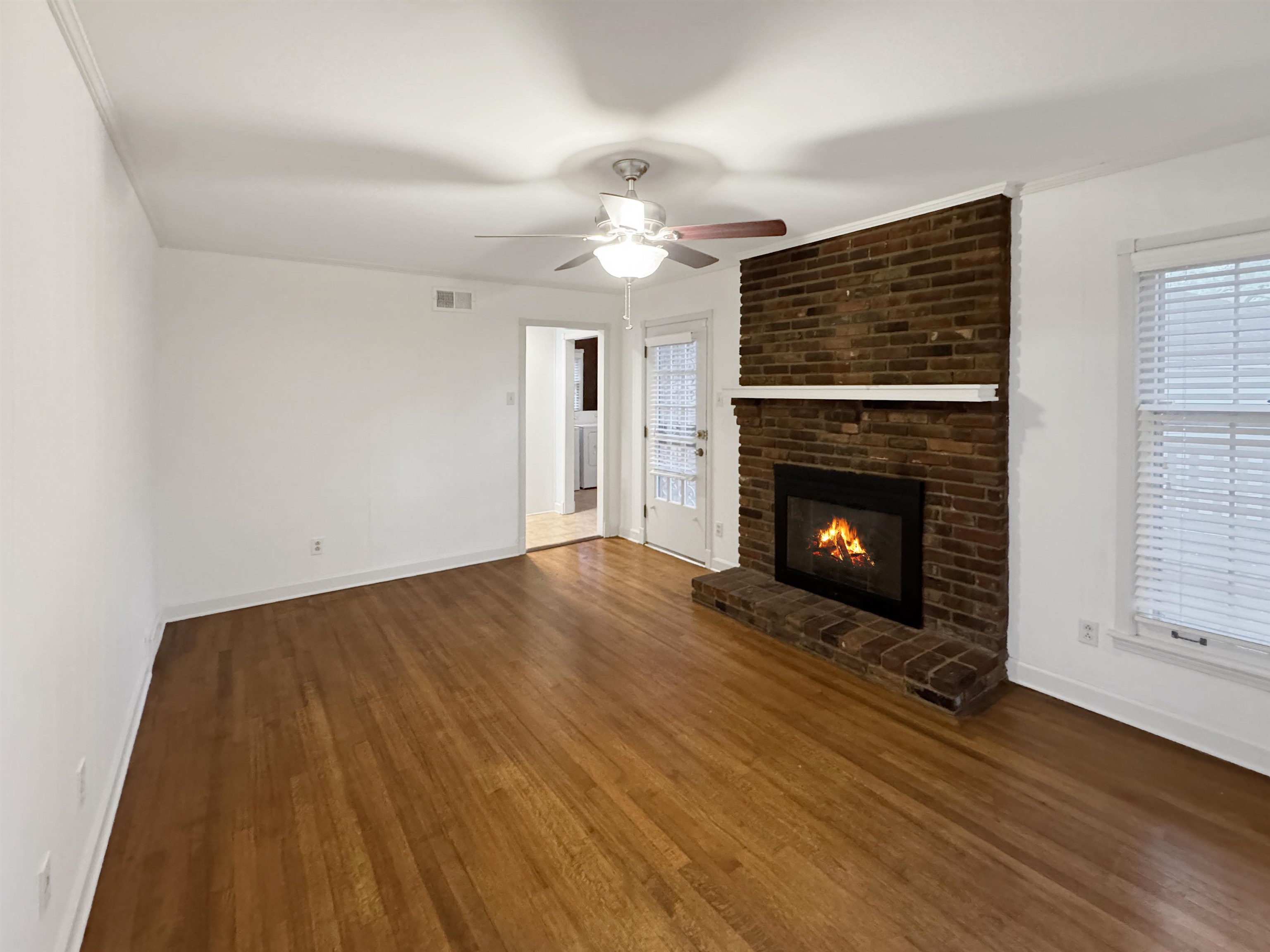 407 Meadvale Road Memphis, TN 38120 - Photo 18 of 36 a view of empty room with wooden floor and fireplace