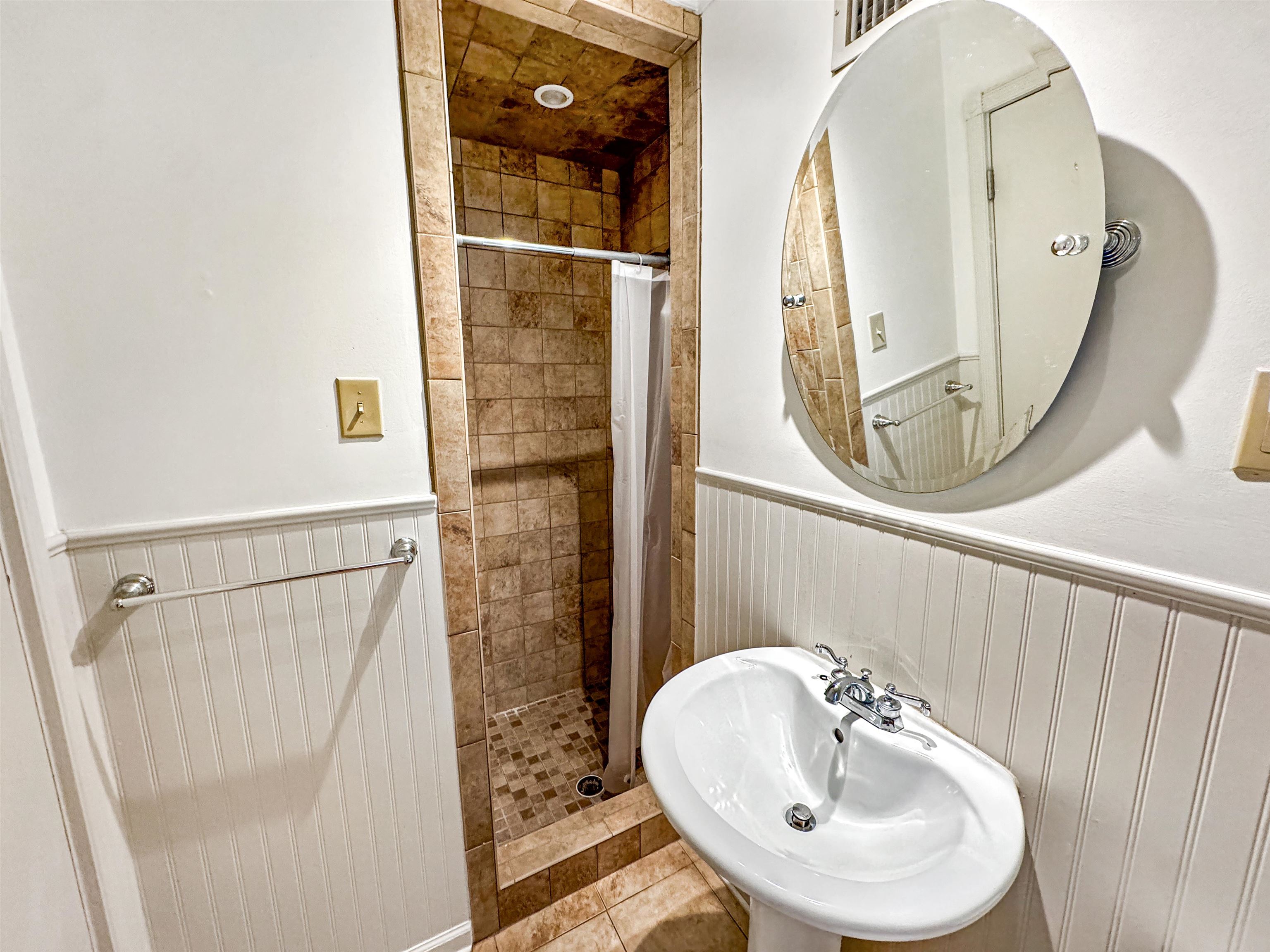 407 Meadvale Road Memphis, TN 38120 - Photo 23 of 36 a bathroom with a sink a mirror a vanity and shower