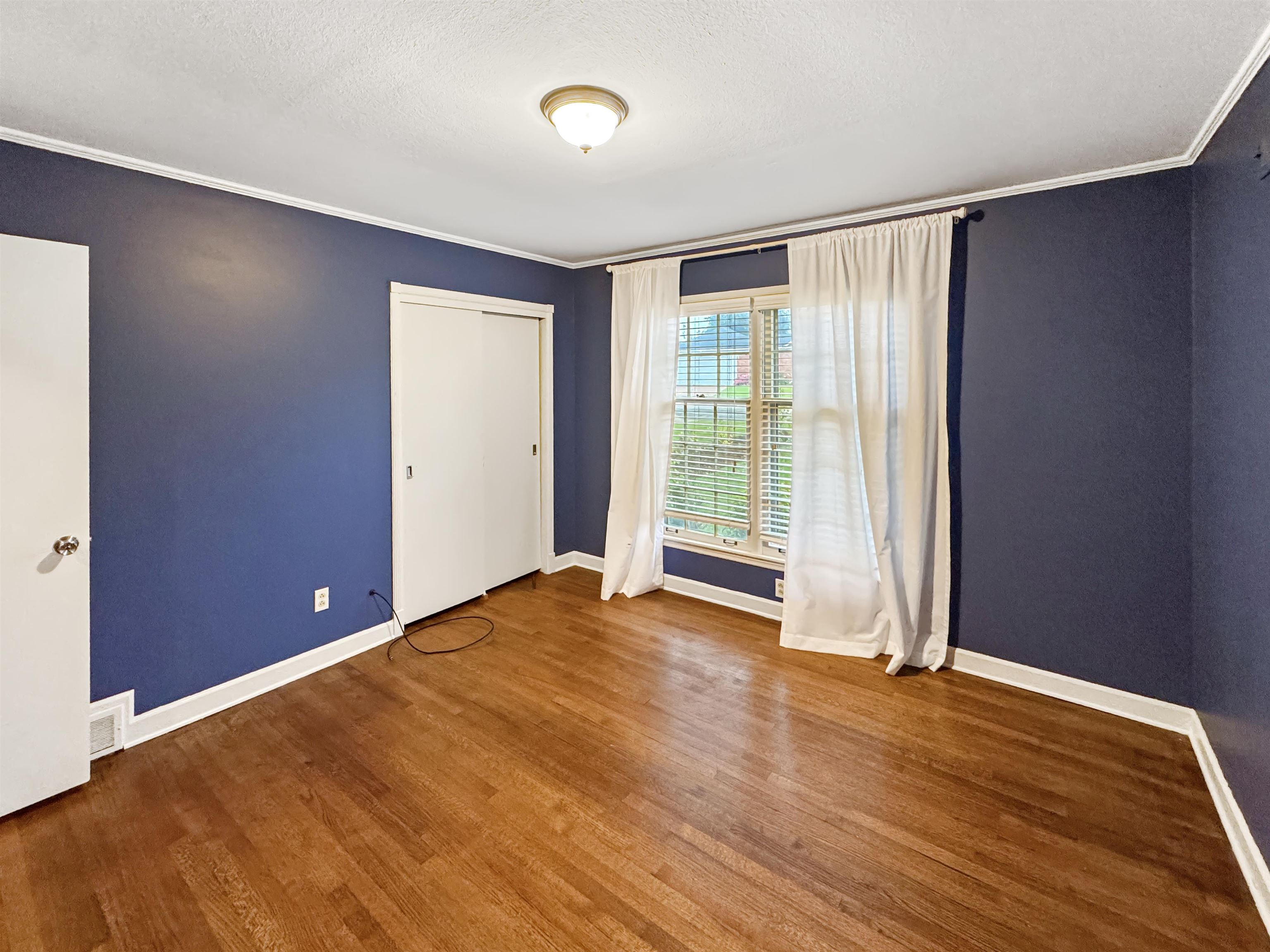 407 Meadvale Road Memphis, TN 38120 - Photo 25 of 37 an empty room with wooden floor and windows