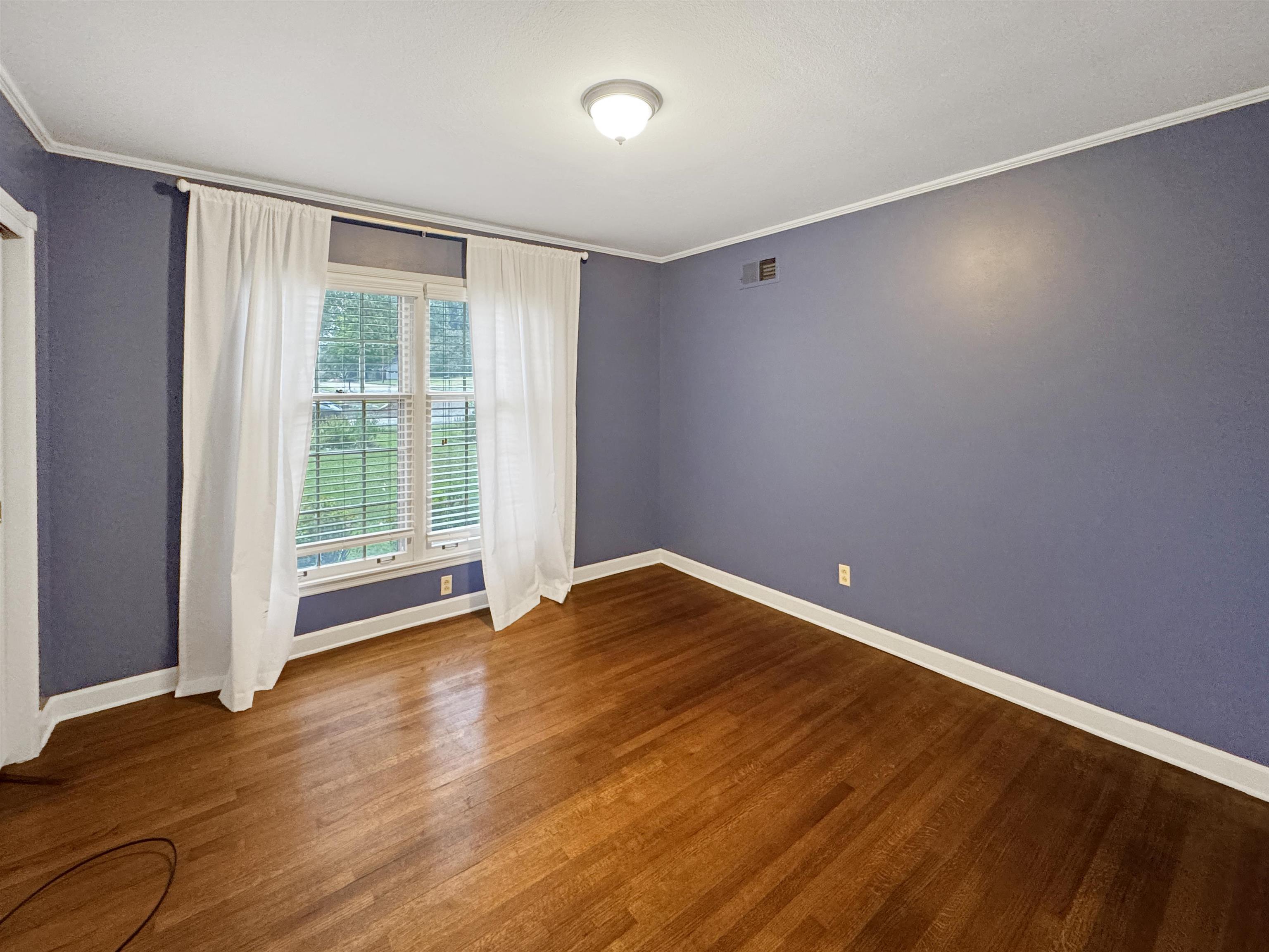 407 Meadvale Road Memphis, TN 38120 - Photo 25 of 36 a view of an empty room with wooden floor and a window