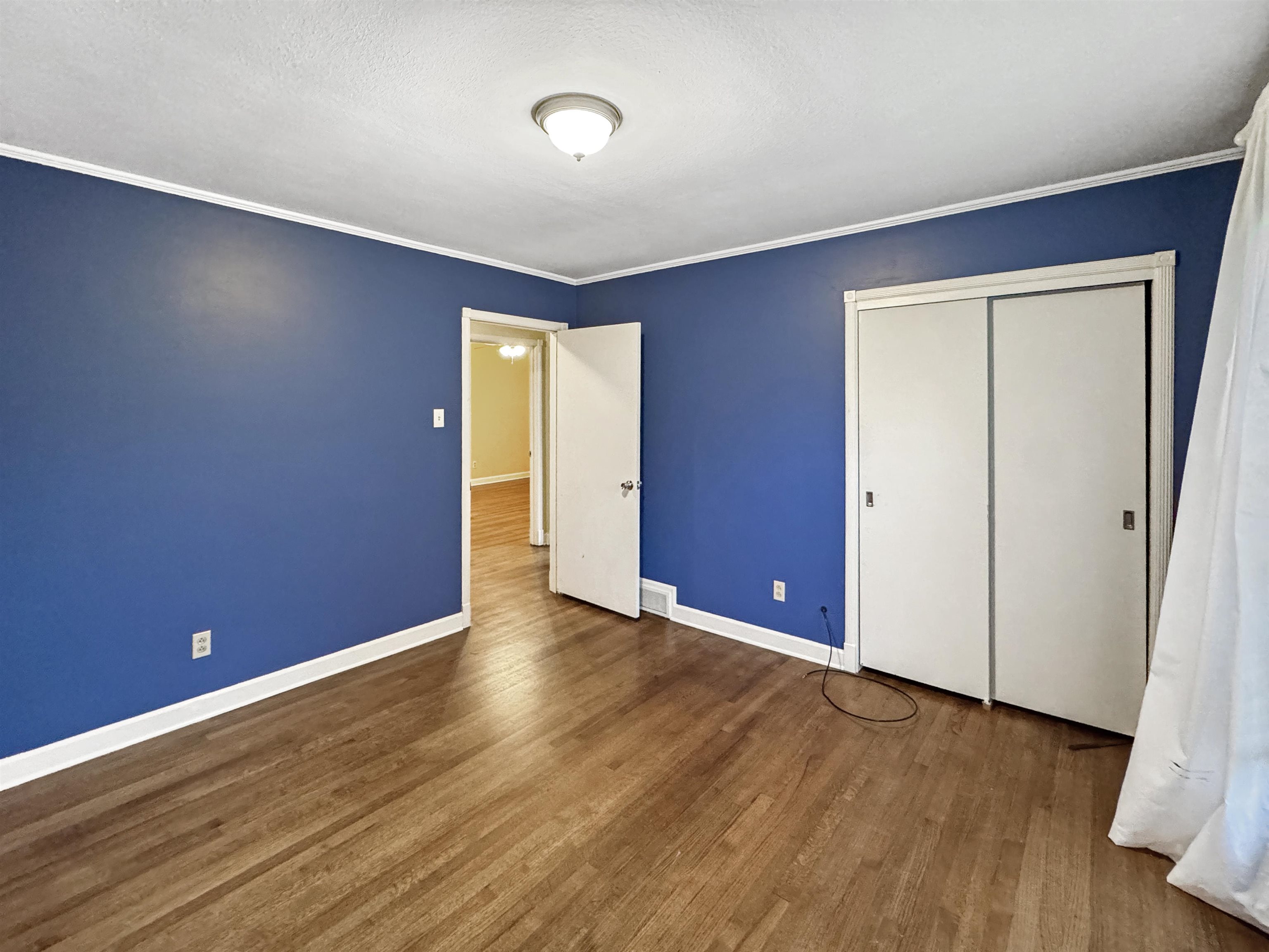 407 Meadvale Road Memphis, TN 38120 - Photo 27 of 37 a view of an empty room with wooden floor and closet