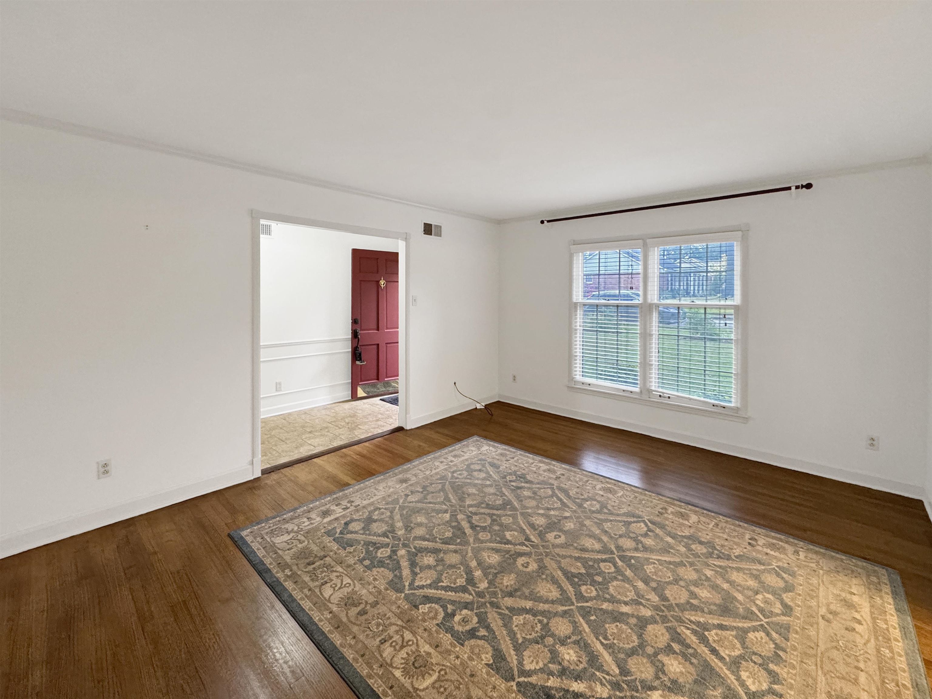 407 Meadvale Road Memphis, TN 38120 - Photo 6 of 36 an empty room with wooden floor and windows