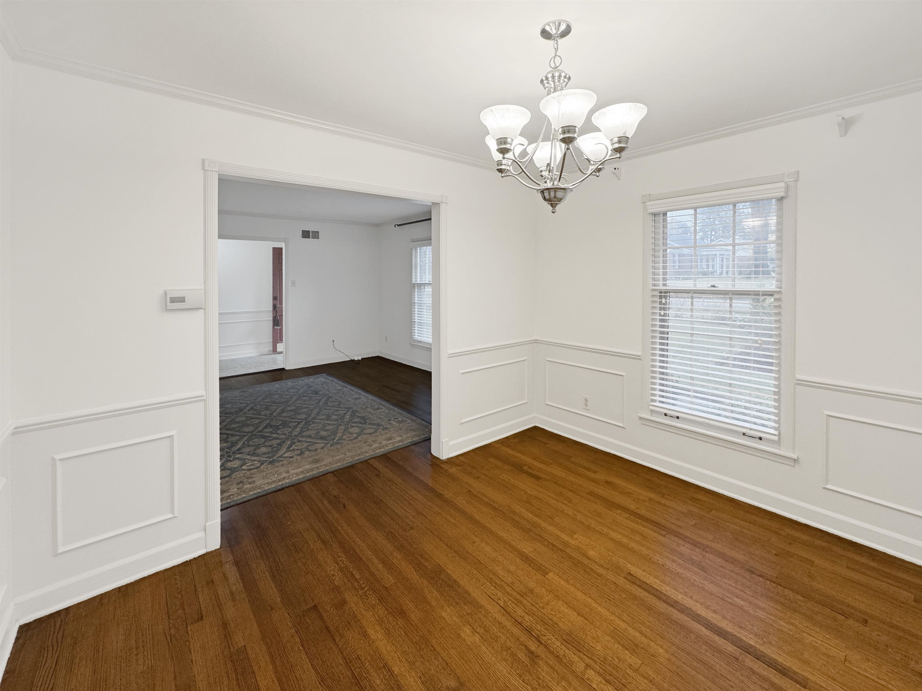 407 Meadvale Road Memphis, TN 38120 - Photo 10 of 37 a view of an empty room with wooden floor and a window