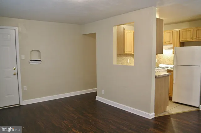 an empty room with wooden floor and a window