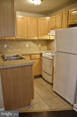a kitchen with stainless steel appliances granite countertop a refrigerator a stove a sink and dishwasher
